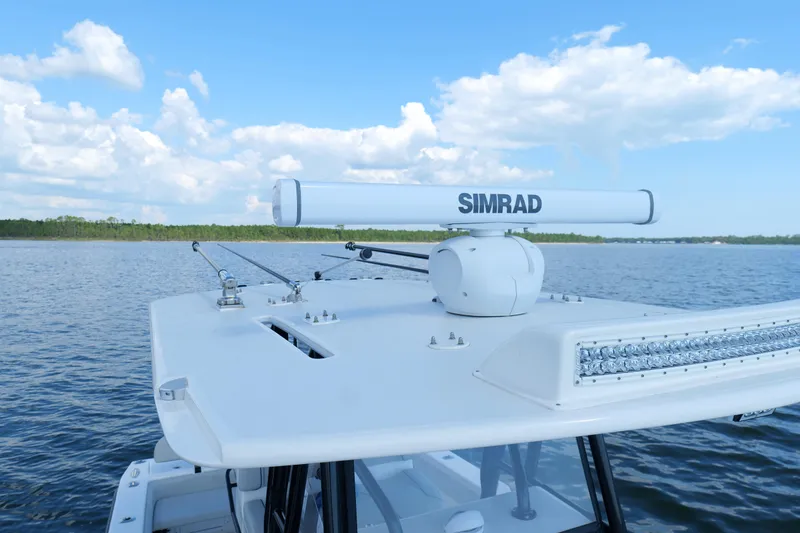 Slide: The Image of 2023 SeaVee 32 boat with Simrad radar on calm waters under blue sky. - 34
