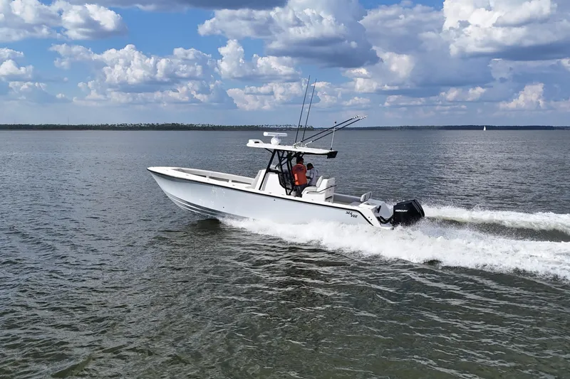 Slide: The Image of 2023 SeaVee 32 boat cruising on open water under a cloudy sky. - 48