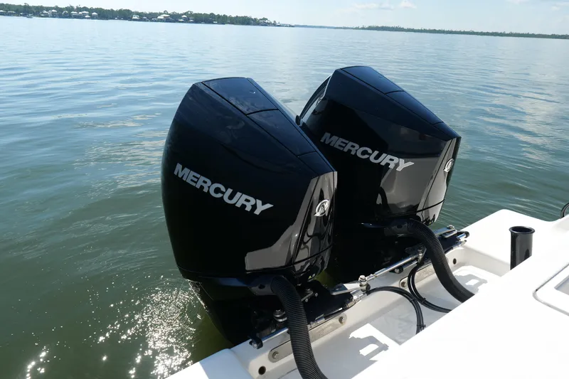 Slide: The Image of Twin Mercury outboard engines on a 2023 SeaVee 32 boat, glistening on calm waters. - 8