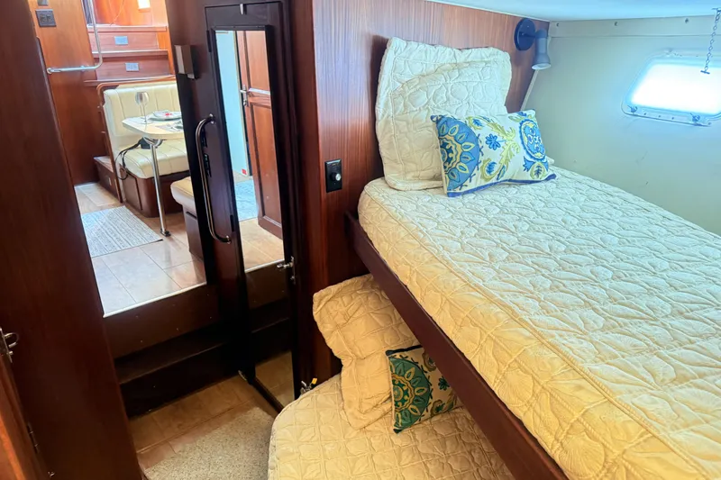 Slide: The Image of Interior of 1987 Hatteras 54 Motor Yacht with cozy twin beds and dining area. - 15