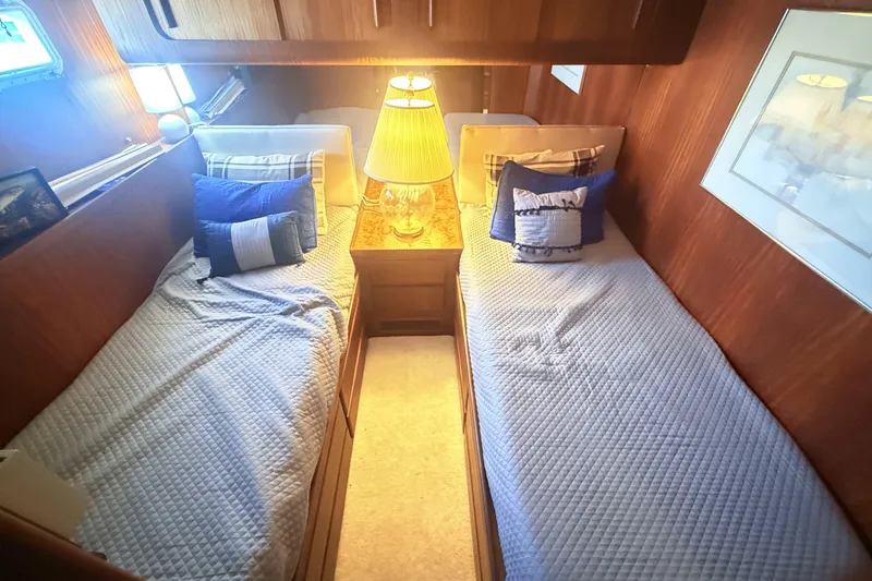 Slide: The Image of 1987 Hatteras 54 Motor Yacht cabin with twin beds and cozy lighting. - 18