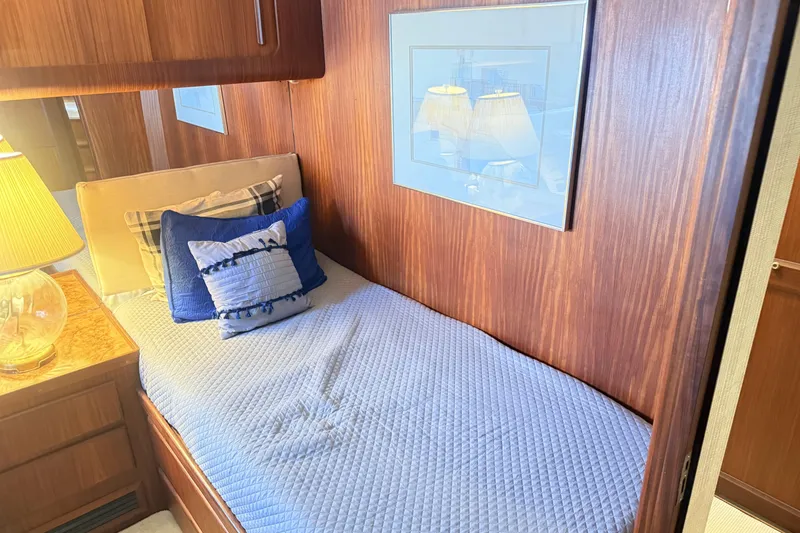Slide: The Image of Cozy cabin interior of 1987 Hatteras 54 Motor Yacht with blue bedding and wooden paneling. - 19