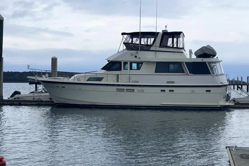 Slide: The Image of 1987 Hatteras 54 Motor Yacht cruising on calm blue waters under clear skies. - 2