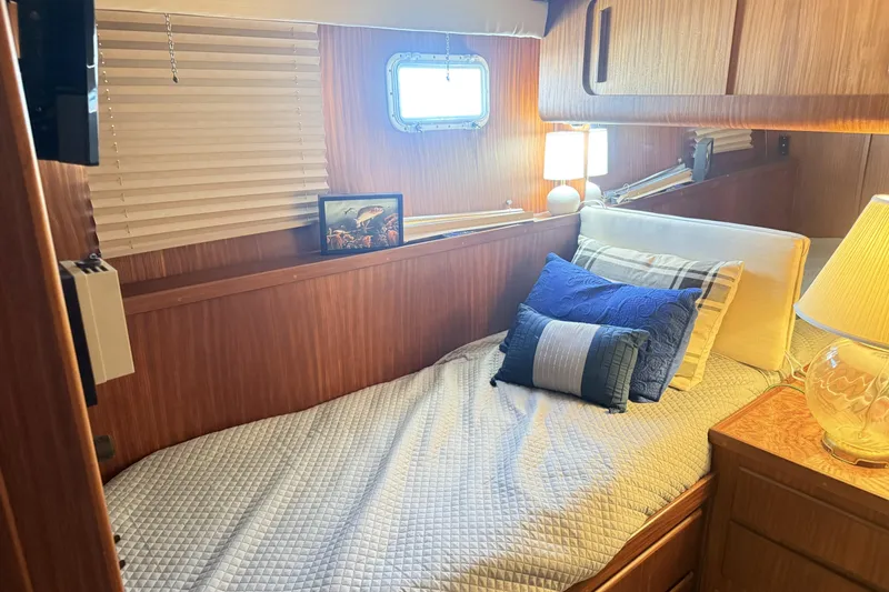 Slide: The Image of Cozy cabin interior of 1987 Hatteras 54 Motor Yacht with bed and decorative pillows. - 20