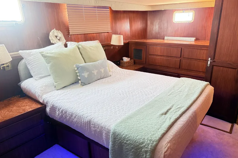 Slide: The Image of Luxurious bedroom interior of 1987 Hatteras 54 Motor Yacht with elegant wood paneling. - 23