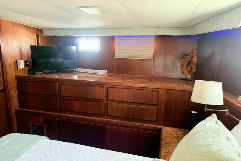 Slide: The Image of Interior of 1987 Hatteras 54 Motor Yacht with TV, wooden cabinetry, and lamp. - 24