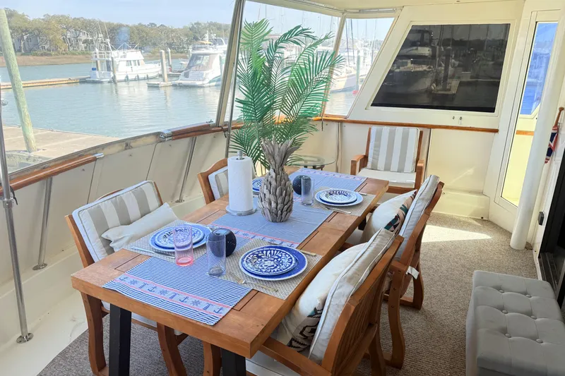 Slide: The Image of Elegant dining area on 1987 Hatteras 54 Motor Yacht with marina view. - 32