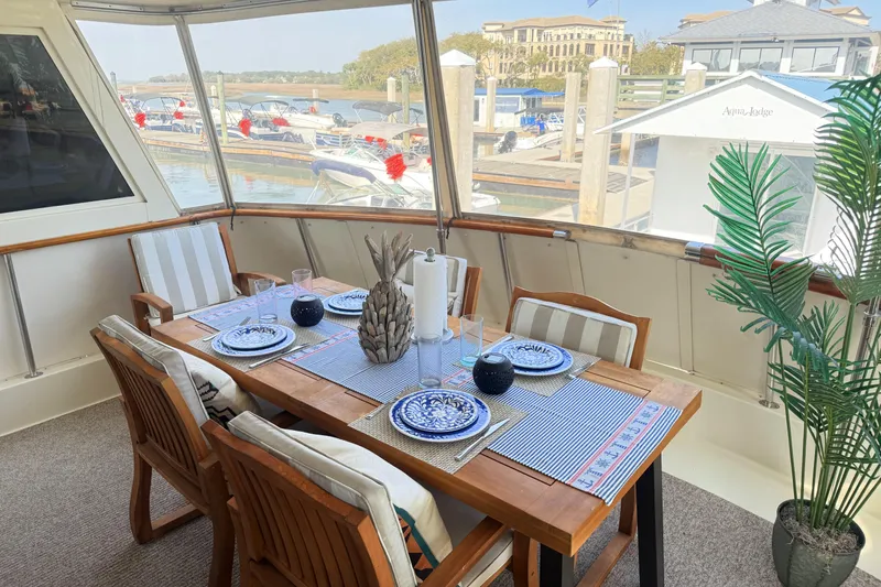 Slide: The Image of Elegant dining area on 1987 Hatteras 54 Motor Yacht with marina view. - 42