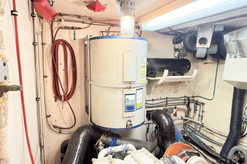 Slide: The Image of Engine room of 1987 Hatteras 54 Motor Yacht with water heater and piping. - 48