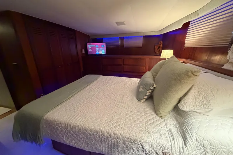 Slide: The Image of Luxurious bedroom interior of 1987 Hatteras 54 Motor Yacht with cozy bedding and ambient lighting. - 50