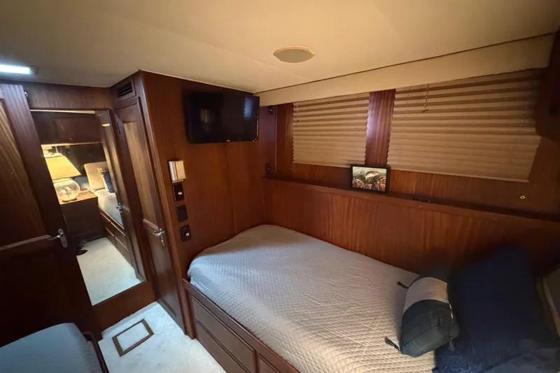 Slide: The Image of Cozy cabin interior of 1987 Hatteras 54 Motor Yacht with wood paneling and twin beds. - 54