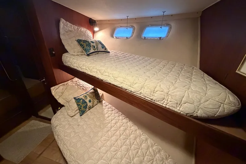 Slide: The Image of Interior of 1987 Hatteras 54 Motor Yacht with cozy bunk beds and nautical decor. - 56