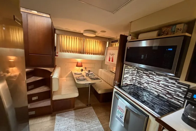 Slide: The Image of 1987 Hatteras 54 Motor Yacht cruising on a serene waterway near a coastal town. - 8