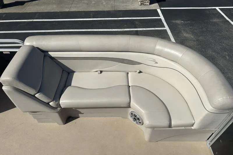 Slide: The Image of 2015 Bennington 22 SLX boat seating, beige upholstery, curved design, outdoor setting. - 10