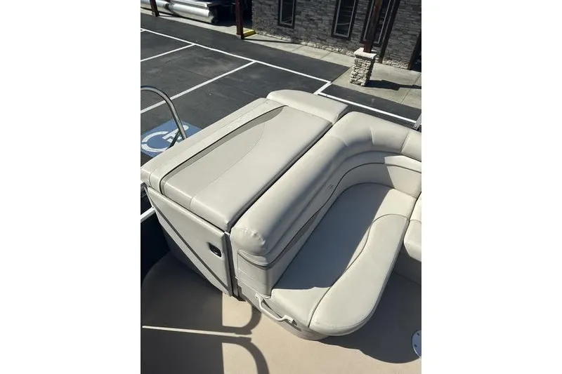 Slide: The Image of 2015 Bennington 22 SLX boat with beige seating, parked in a lot. - 17
