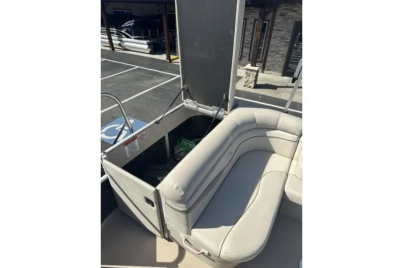 Slide: The Image of 2015 Bennington 22 SLX pontoon boat with beige seating and storage compartment. - 19