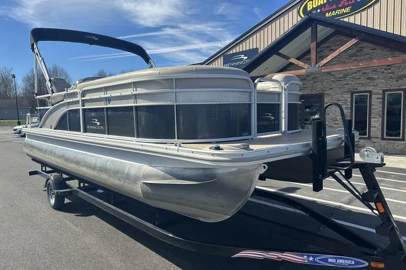 Slide: The Image of 2015 Bennington 22 SLX pontoon boat on trailer, parked outside a marine sales building. - 5