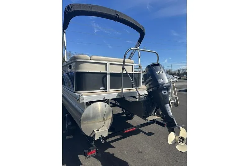 Slide: The Image of 2015 Bennington 22 SLX pontoon boat with outboard motor, parked on trailer. - 7