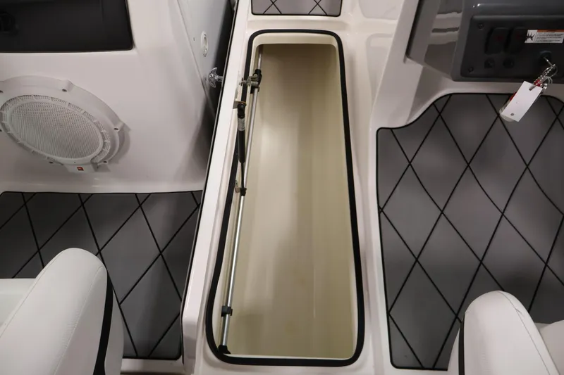 Slide: The Image of 2016 Yamaha Boats SX190 interior storage compartment with speaker and cushioned seating. - 27