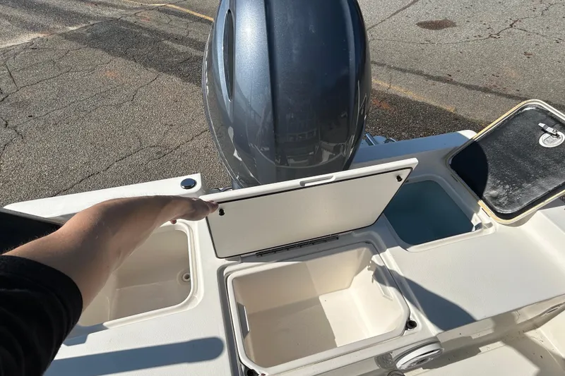 Slide: The Image of 2021 Key West 188 Bay Reef boat with open storage compartments and outboard motor. - 14