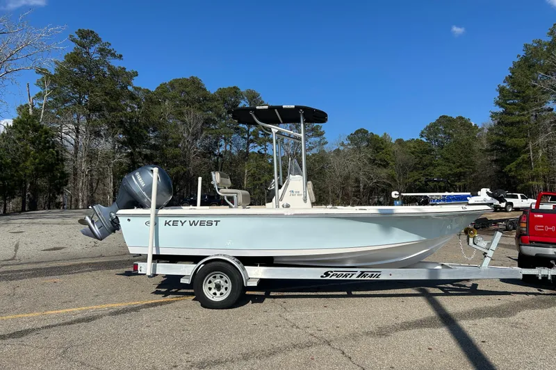 Slide: The Image of 2021 Key West 188 Bay Reef boat on trailer, parked outdoors with Yamaha outboard motor. - 2