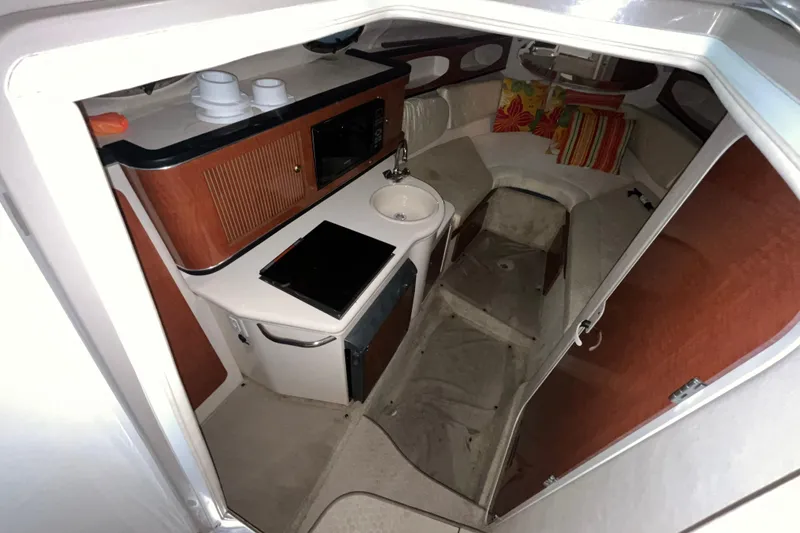 Slide: The Image of 2004 Sea Ray Sundancer 260 cabin interior with kitchenette and seating area. - 13