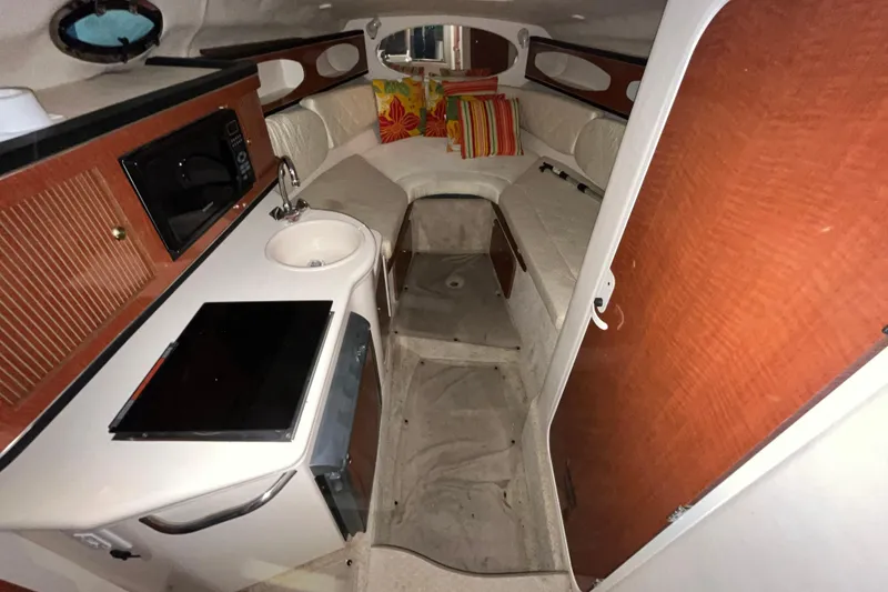 Slide: The Image of 2004 Sea Ray Sundancer 260 cabin interior with kitchenette and seating area. - 14
