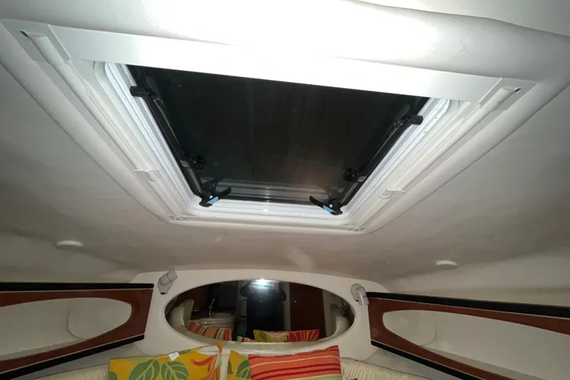 Slide: The Image of Interior cabin view of a 2004 Sea Ray Sundancer 260 with a skylight and colorful cushions. - 17
