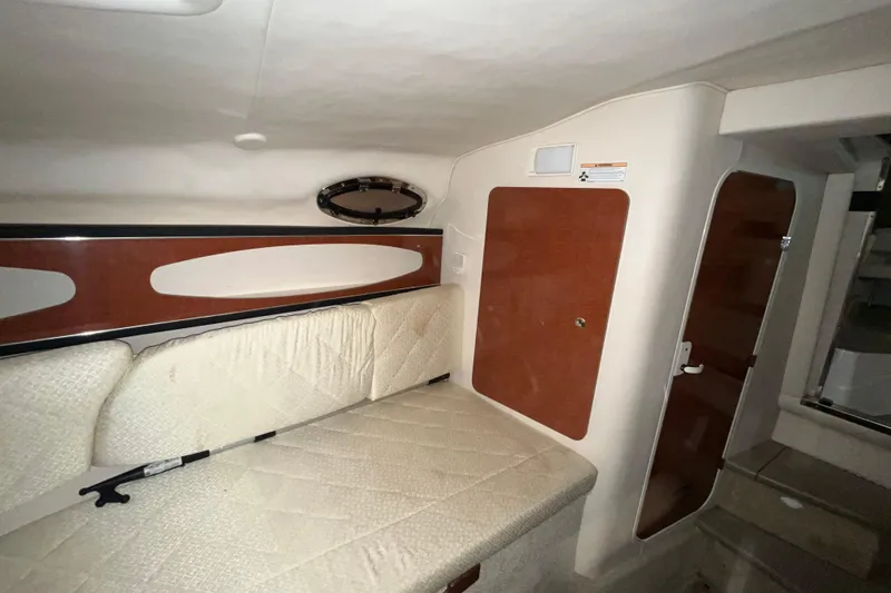 Slide: The Image of Interior cabin of 2004 Sea Ray Sundancer 260 with cushioned seating and wooden accents. - 20