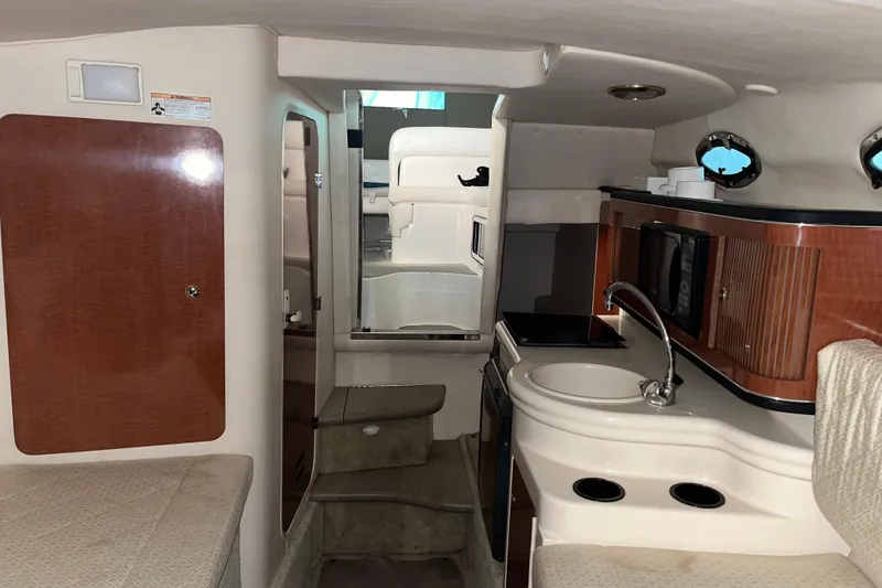 Slide: The Image of 2004 Sea Ray Sundancer 260 cabin interior with kitchenette, sink, and seating area. - 22