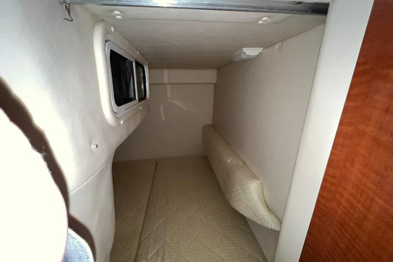 Slide: The Image of 2004 Sea Ray Sundancer 260 cabin interior with window and cushioned seating. - 27