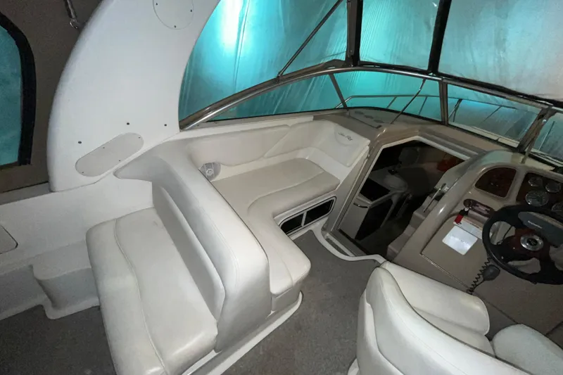Slide: The Image of 2004 Sea Ray Sundancer 260 interior with helm, seating, and cabin entrance. - 3