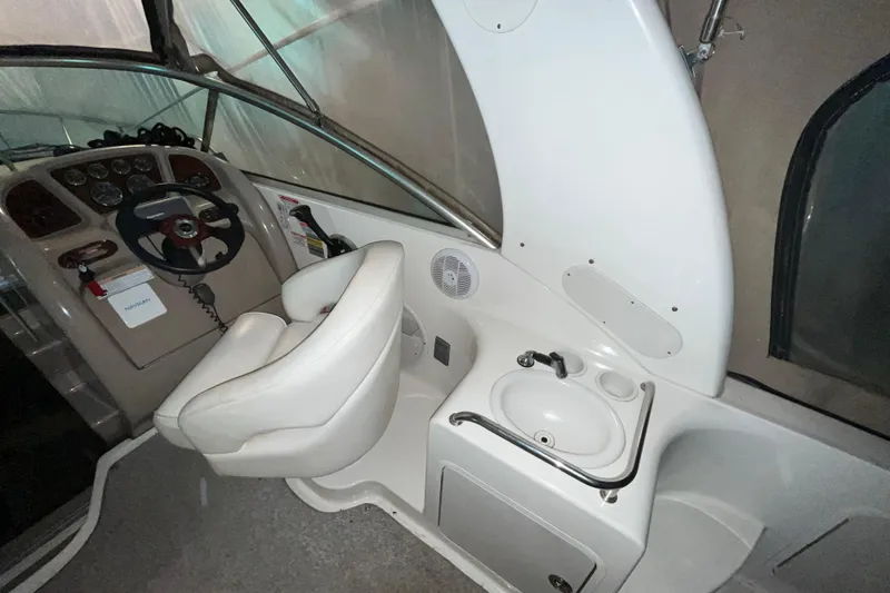 Slide: The Image of 2004 Sea Ray Sundancer 260 cockpit with steering wheel, seat, and sink. - 5