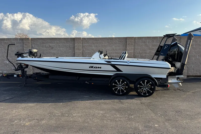 The Image of 2024 Ikon Boats 21 model on trailer, sleek design, dual motors, clear sky background. - 1