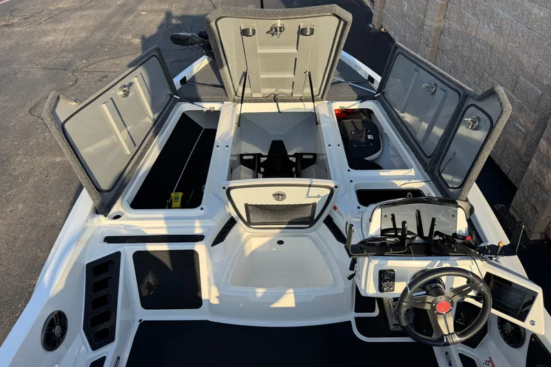 Slide: The Image of 2024 Ikon Boats 21 interior with open storage compartments and steering wheel. - 17