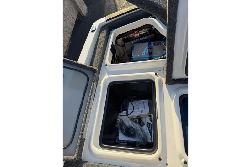 Slide: The Image of Open storage compartments on a 2024 Ikon Boats 21, showing equipment and accessories. - 18