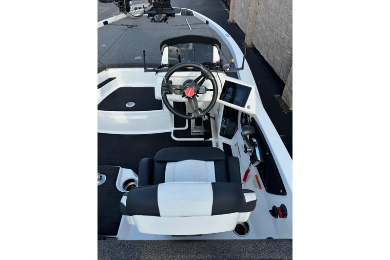 Slide: The Image of 2024 Ikon Boats 21 cockpit with steering wheel, control panel, and seating. - 21