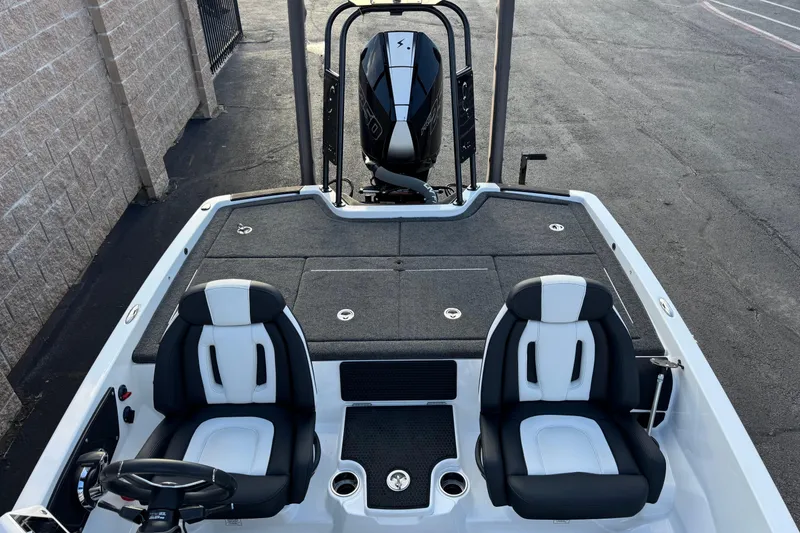 Slide: The Image of 2024 Ikon Boats 21 model with dual seats and rear motor, parked on pavement. - 7