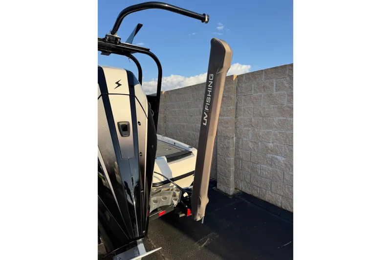 Slide: The Image of 2024 Ikon Boats 21 with LUV Fishing equipment, parked near a stone wall. - 9