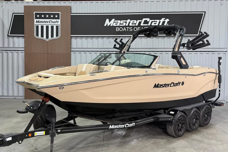 The Image of 2025 MasterCraft X24 boat on trailer in showroom setting. - 13