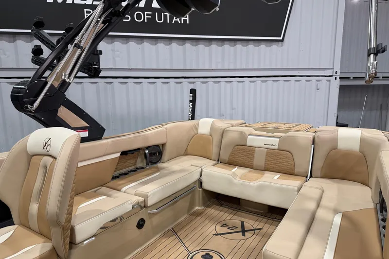 Slide: The Image of 2025 MasterCraft X24 boat interior with beige seating and sleek design. - 16