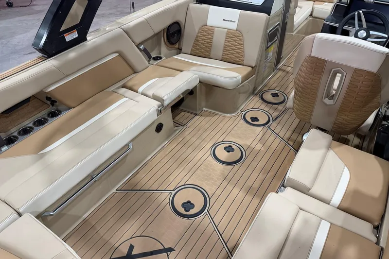 Slide: The Image of 2025 MasterCraft X24 boat interior with tan leather seating and sleek wood flooring. - 21