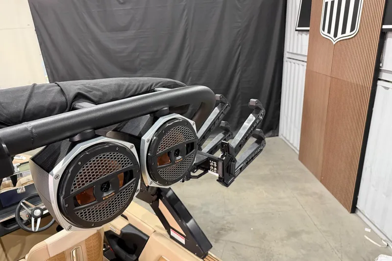 Slide: The Image of 2025 MasterCraft X24 boat with premium audio speakers and wakeboard racks in a showroom. - 26