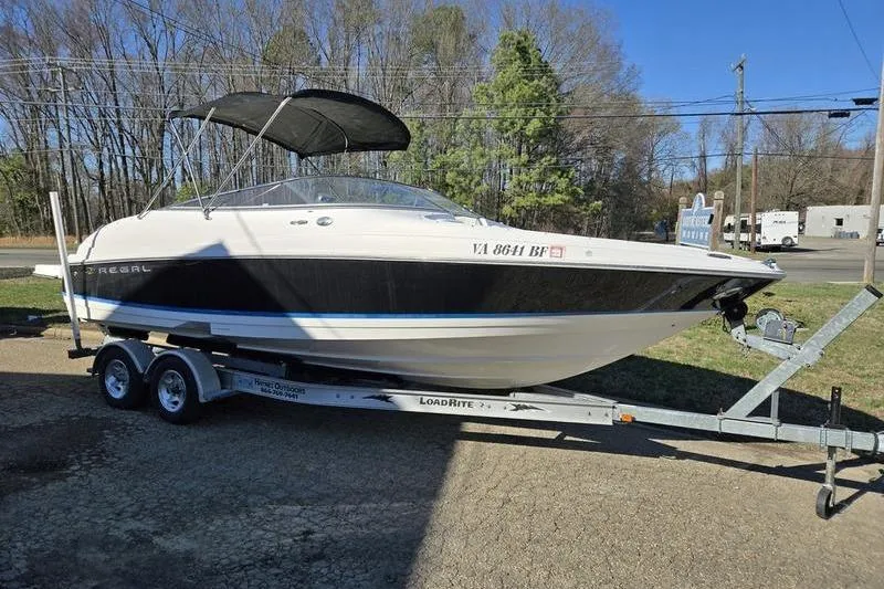 The Image of 2005 Regal 2400 Bowrider boat on trailer with canopy, parked outdoors. - 0