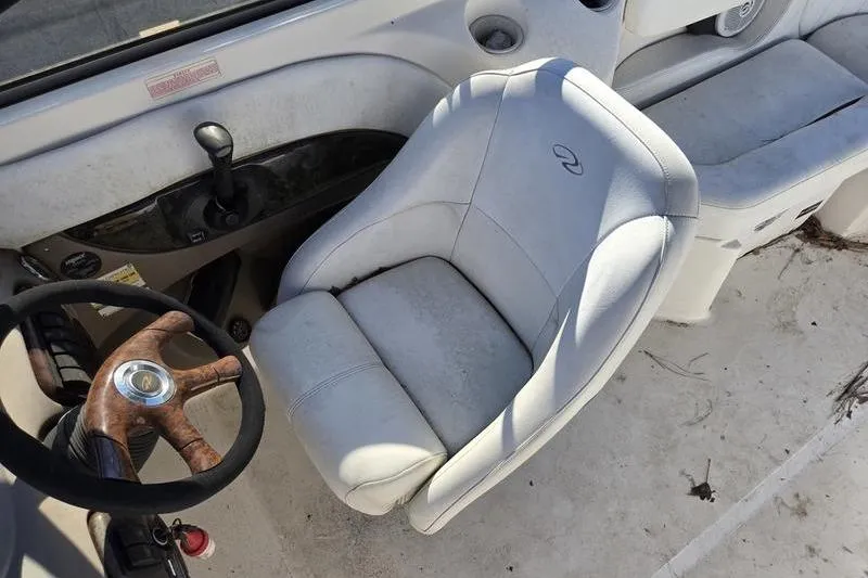 Slide: The Image of 2005 Regal 2400 Bowrider interior with steering wheel and white captain's chair. - 14