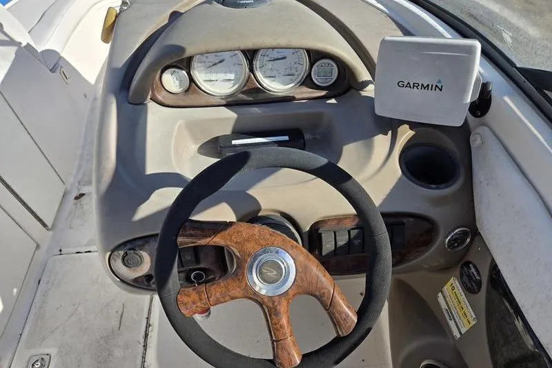 Slide: The Image of 2005 Regal 2400 Bowrider dashboard with Garmin GPS and wooden steering wheel. - 16
