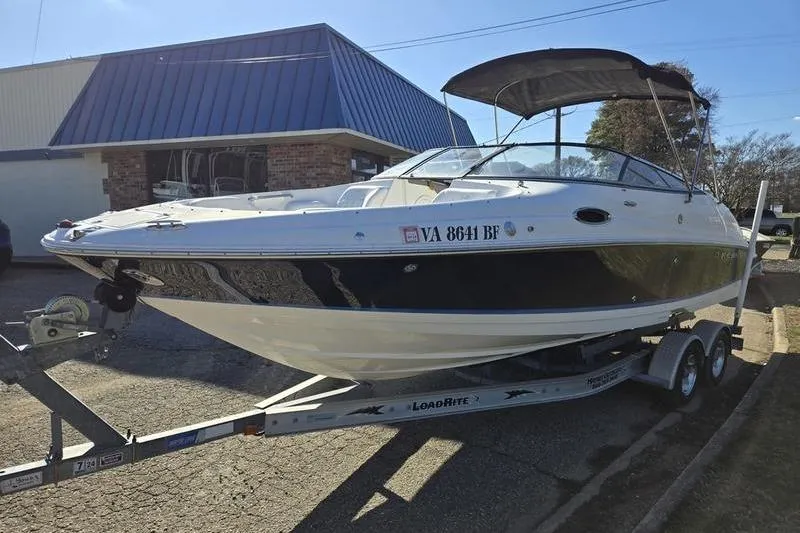Slide: The Image of 2005 Regal 2400 Bowrider boat on trailer, parked outside a building. - 4