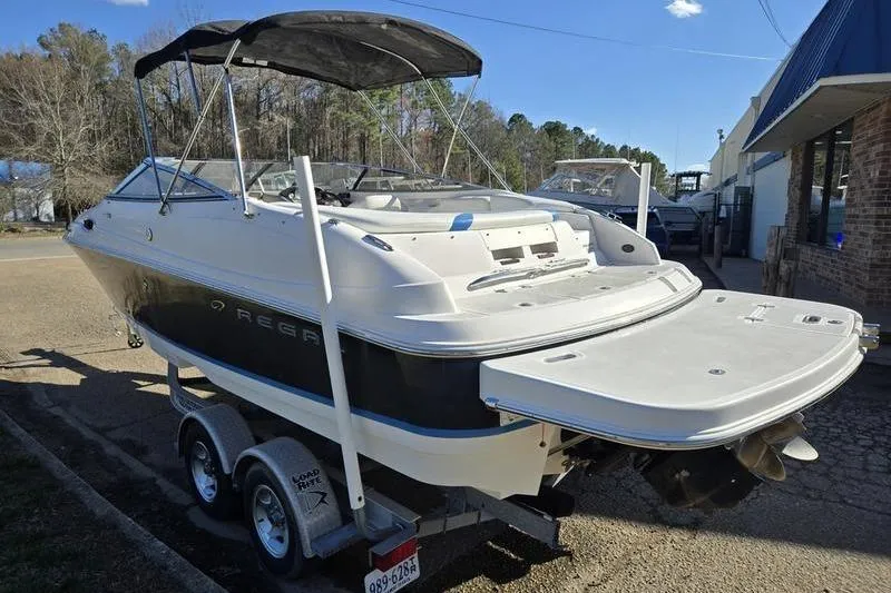 Slide: The Image of 2005 Regal 2400 Bowrider boat on trailer with canopy, parked outdoors. - 6
