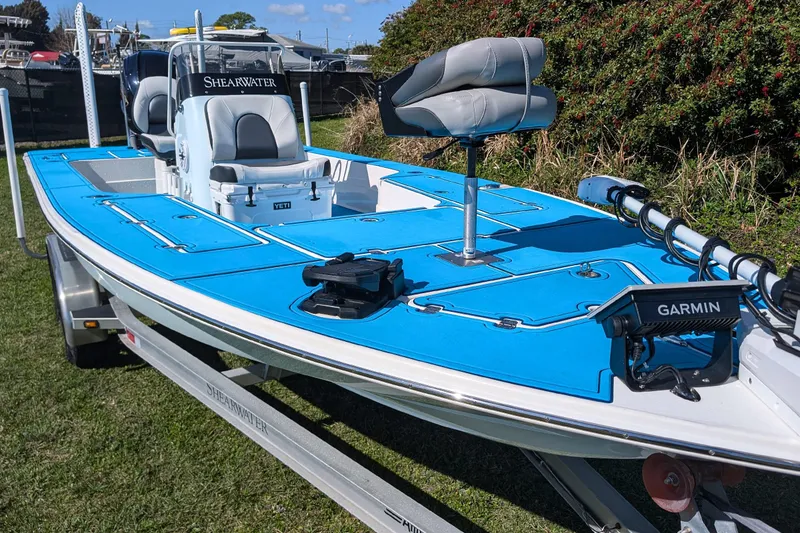 Slide: The Image of 2023 ShearWater X22 Hybrid boat with blue deck, Garmin equipment, and trailer. - 11