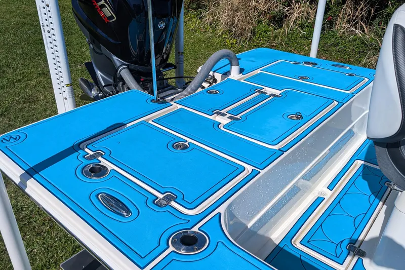 Slide: The Image of 2023 ShearWater X22 Hybrid boat deck with blue non-slip surface and storage compartments. - 14